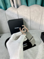 Light gray belt with oval CC buckle, styled on chair with dust bag