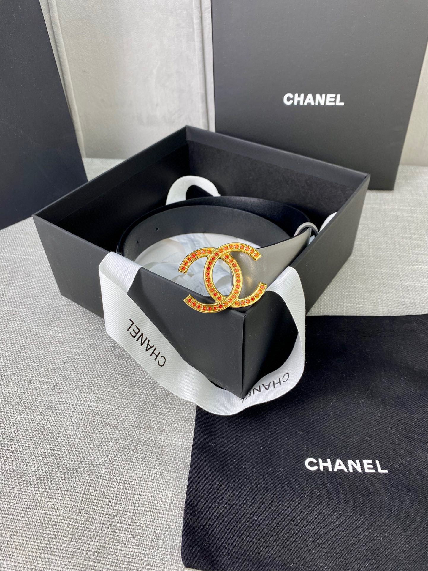 Light gray belt with oval CC buckle in gift box with black tissue paper