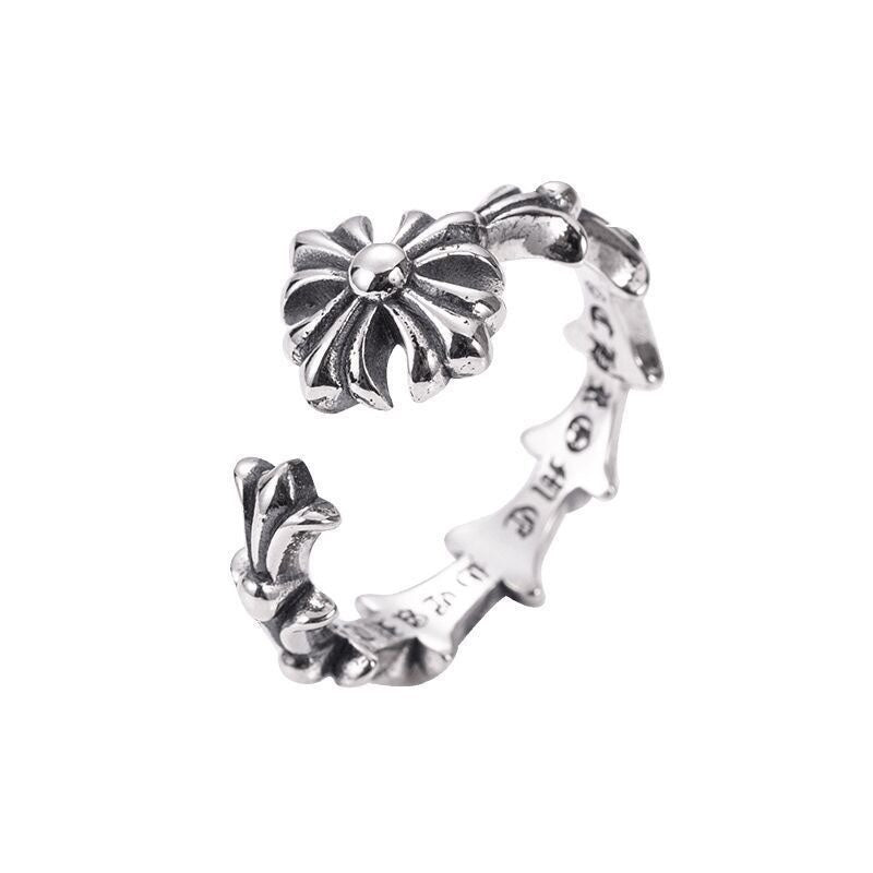 Silver-tone floral charm bracelet viewed from the side, open cuff with flower centerpiece