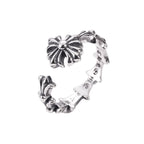 Silver-tone floral charm bracelet viewed from the side, open cuff with flower centerpiece
