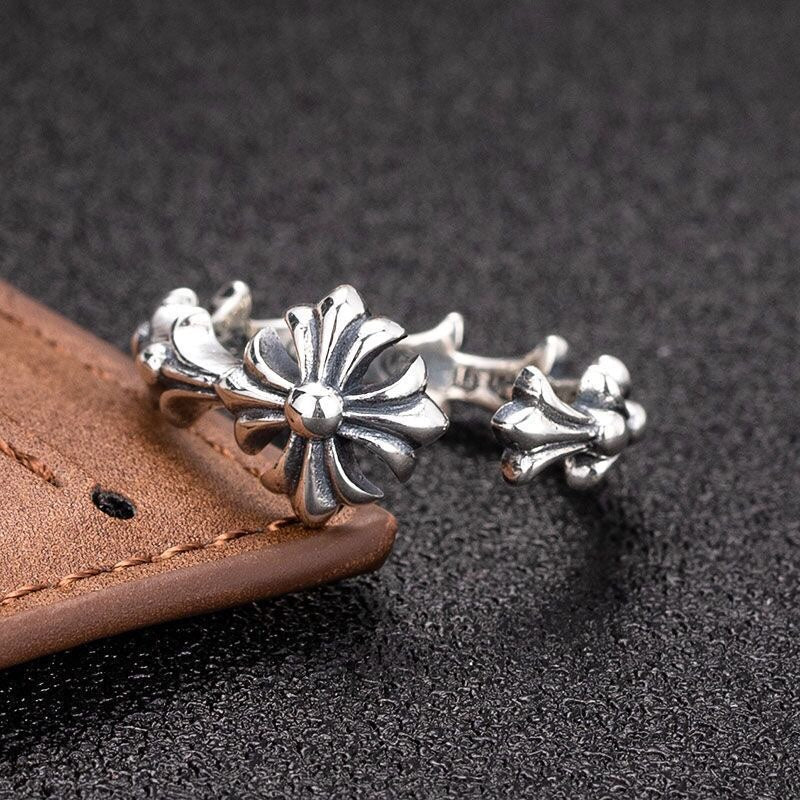 Close-up of silver-tone floral charm bracelet with flower motif on open cuff