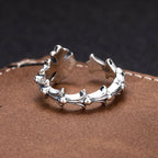 Silver-tone floral charm bracelet with ring-like band and textured flower accents