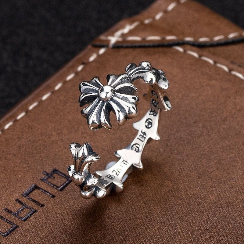 Silver-tone floral charm bracelet with multiple flower charms on an open cuff