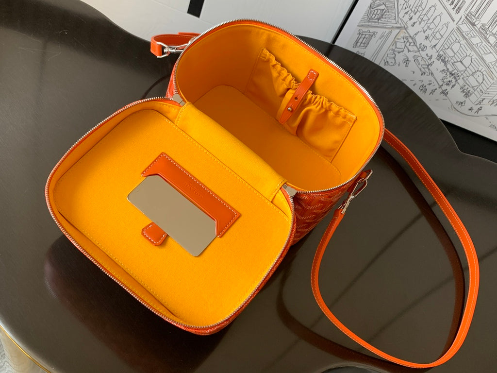 Small orange bag open to show bright yellow interior and inner zip pocket