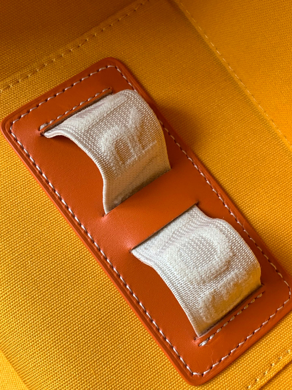 Goyard bag interior slot detail with stitched brown leather and two fabric loops