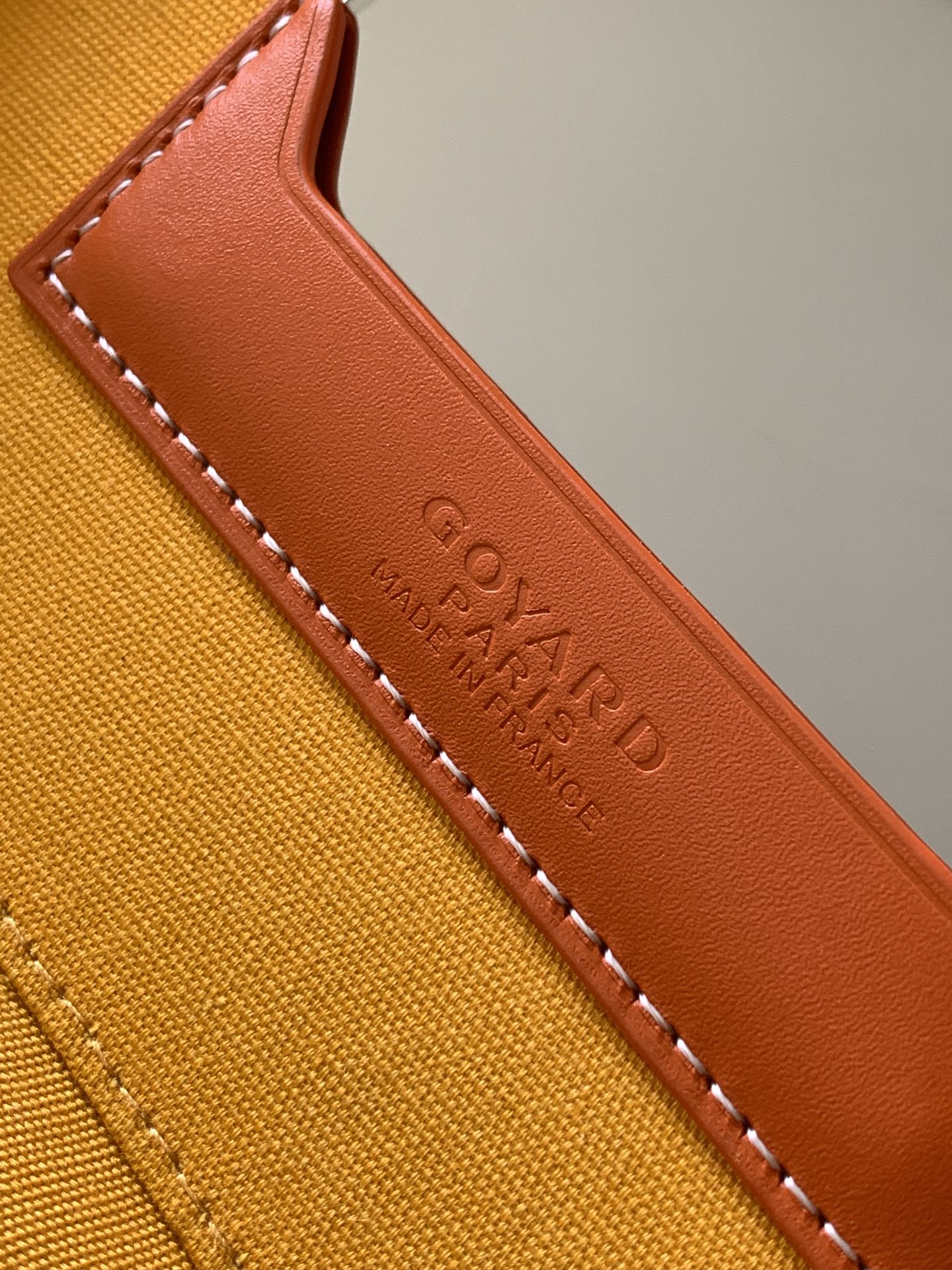 Goyard bag leather edge trim detail in tan with stitched edging and embossed text
