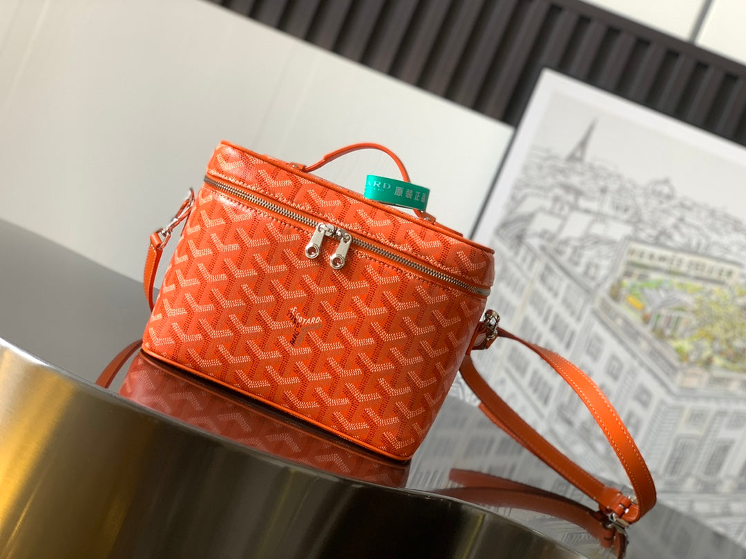 Small orange patterned crossbody bag with top handle and gold-tone zipper detail