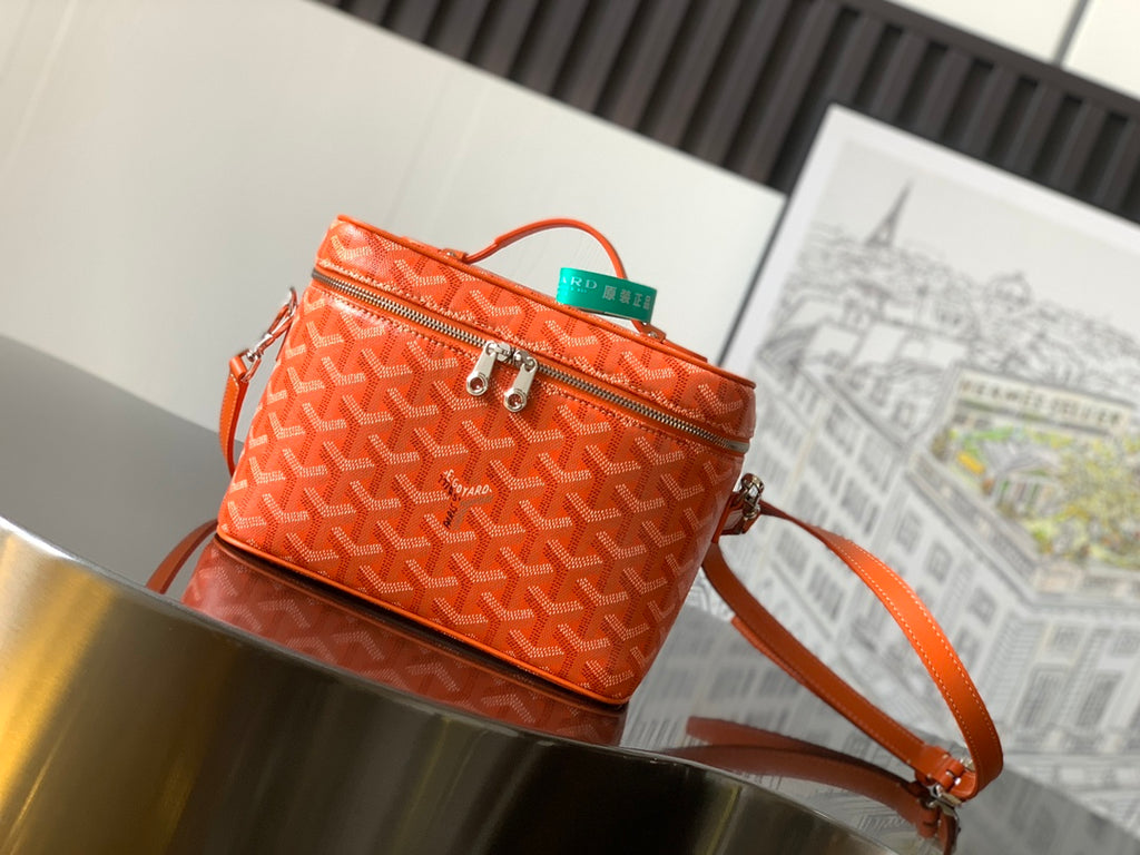 Goyard bag in orange with signature monogram, top zip, and crossbody strap