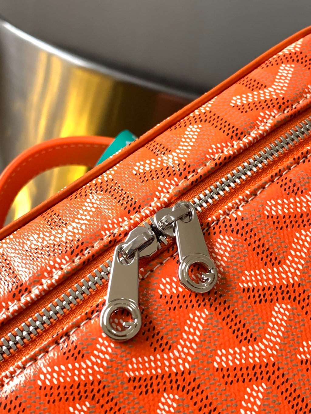 Orange zip compartment with silver zipper pull and round D-ring hardware