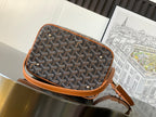 Small crossbody bag with Goyard-print canvas exterior, tan piping, and adjustable leather strap.