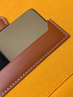 Goyard embossed logo leather label on orange canvas bag with stitched edge
