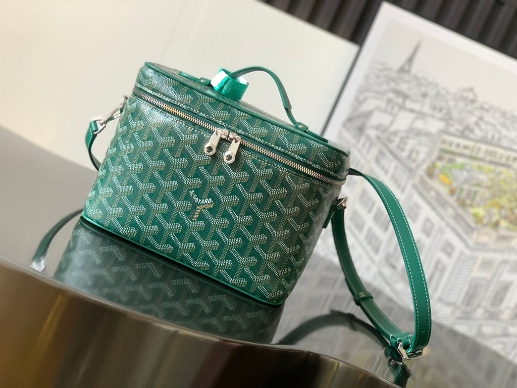 Green small patterned crossbody bag with top handle, double zip, and teal strap hardware
