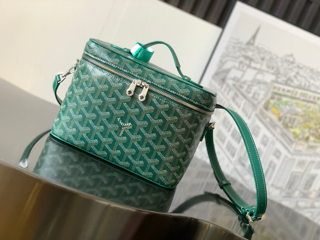Goyard bag in teal with repeating geometric pattern, top zip and short handle