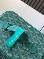Goyard teal bag detail with leather corner tab, front strap loop, and brand tag