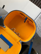 Orange-lined interior of blue patterned small bag with zip and inner pockets