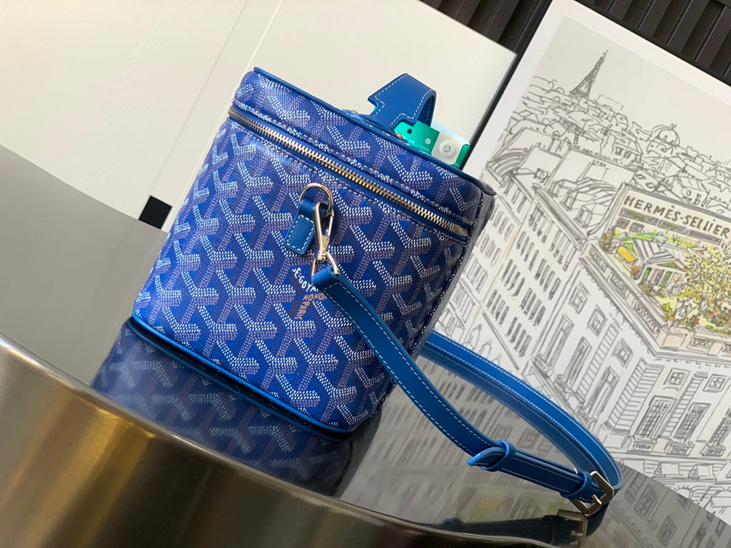 Blue patterned top-zip crossbody bag with short handle, long strap, gold zipper pull