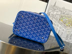 Blue patterned small bag with crossbody strap, zip top, and metal feet