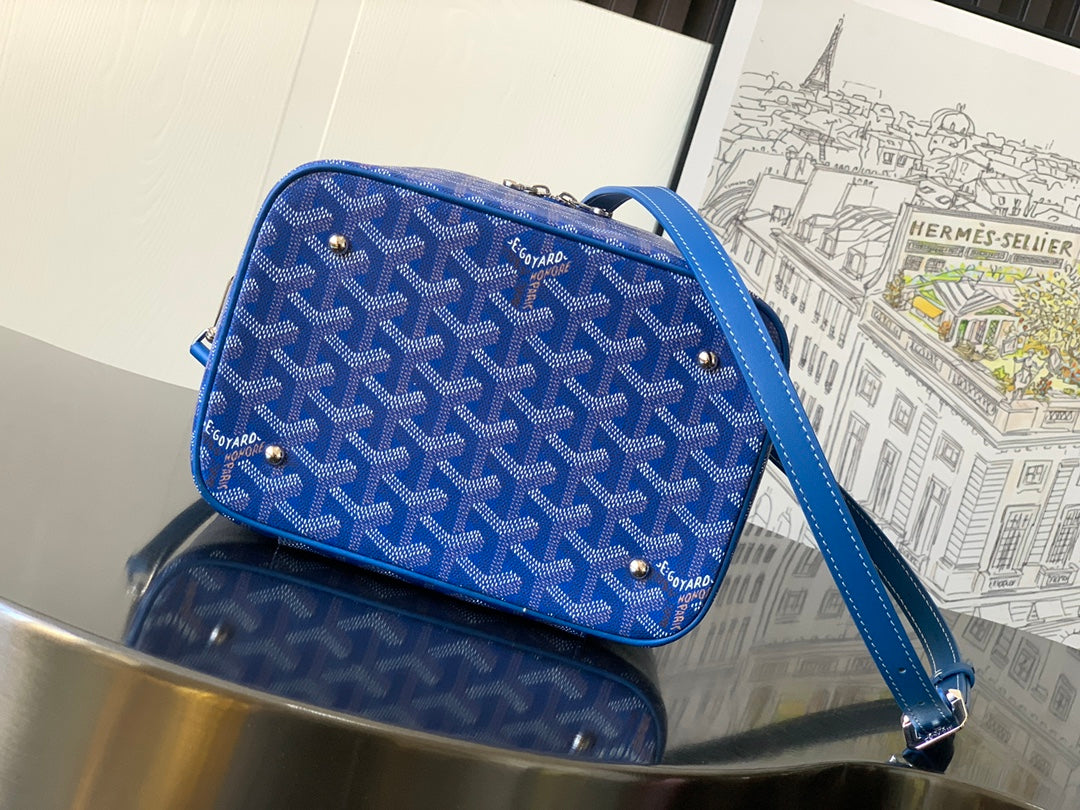 Blue patterned crossbody bag with gold studs, zipper closure, and adjustable strap