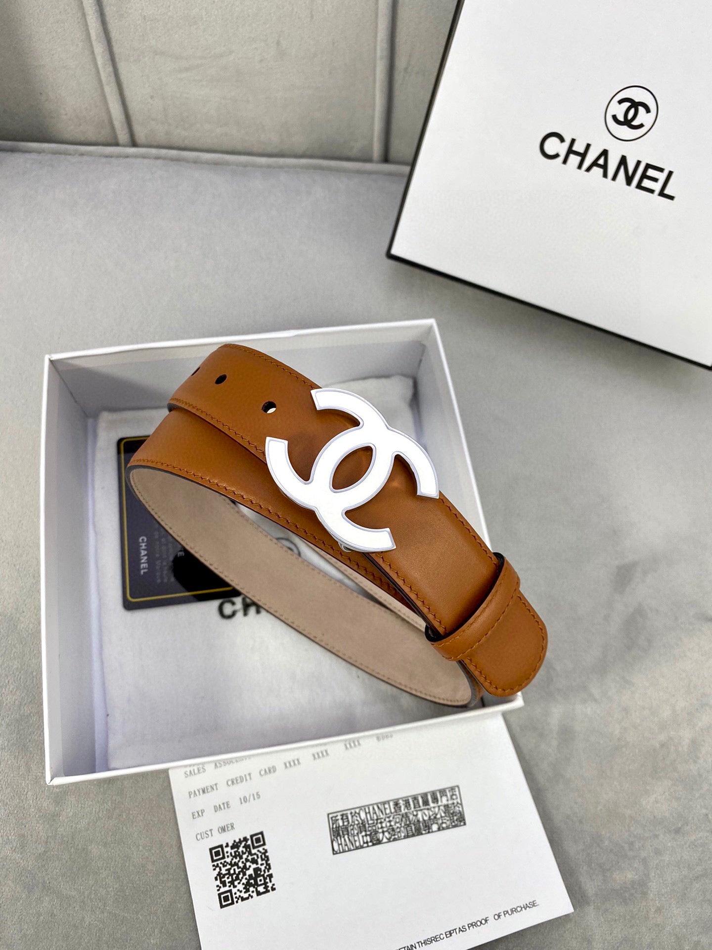 Chanel belt detail, tan leather strap with gold-tone CC logo buckle and punch holes
