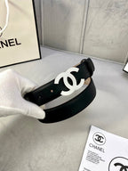 Black leather belt with gold CC buckle, held to show the side profile