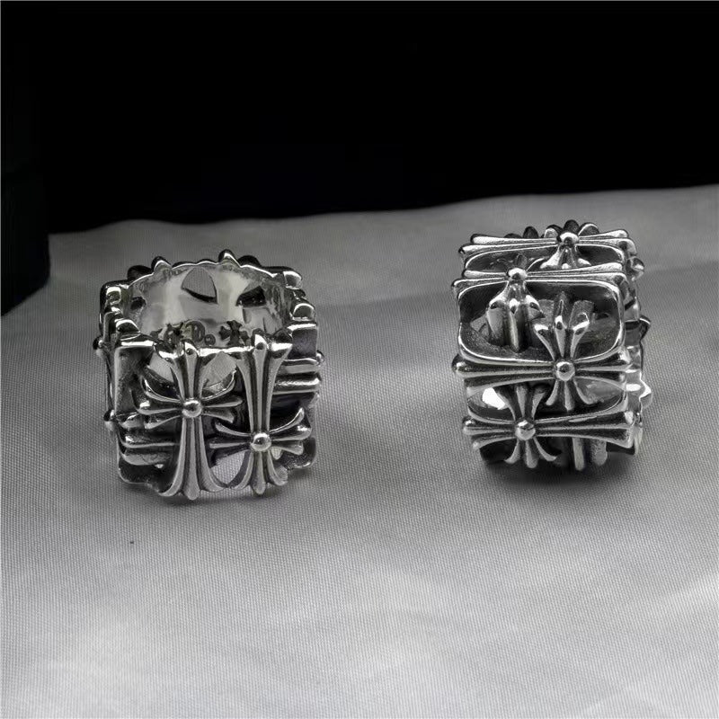Pair of chrome rings with ornate floral cross and starburst detailing