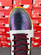 Low-top basketball shoe toe view: white upper with purple vamp and red laces