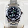 Rolex watch with black dial, green accents, stainless steel bracelet