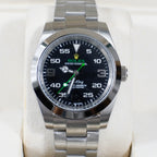 Rolex watch with black dial, green accents, stainless steel bracelet