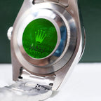 Rolex watch case back with green crown emblem and knurled edge
