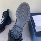 Black suede ankle boot outsole view with tread, grid pattern and molded logo