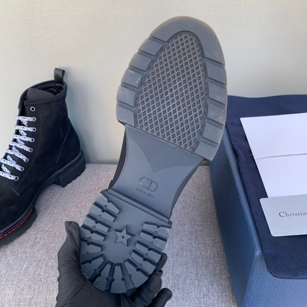 Black suede ankle boot outsole view with tread, grid pattern and molded logo