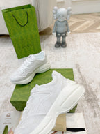 White Gucci lace-up sneakers angled on green box with heel and side detail