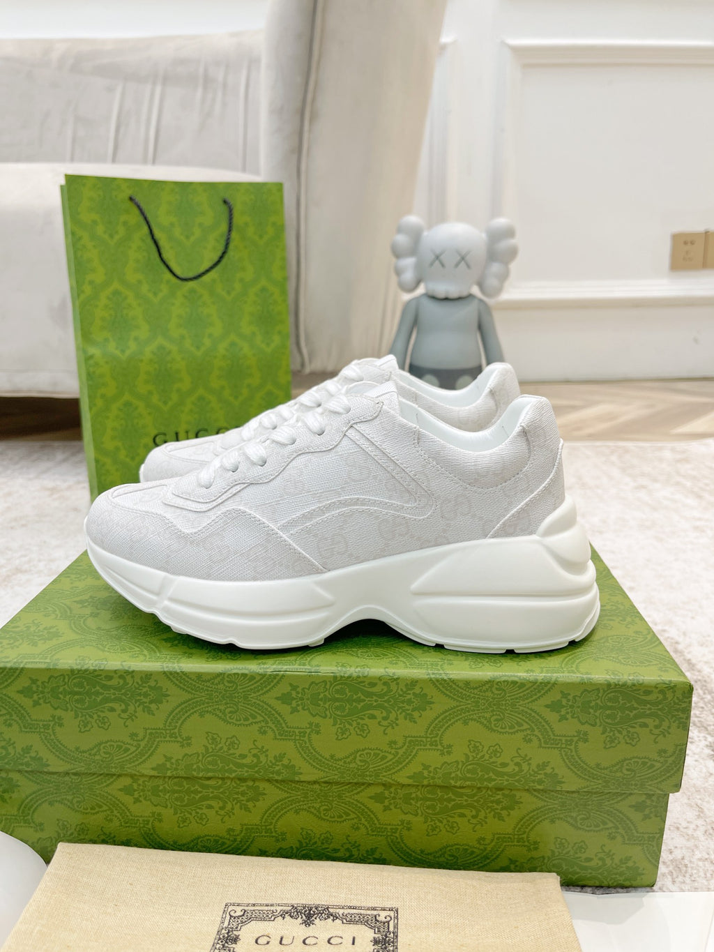 White Gucci lace-up sneaker, three-quarter side view on green Gucci box