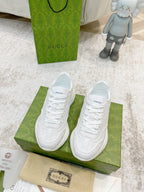 Pair of white Gucci lace-up sneakers with textured pattern and thick sole