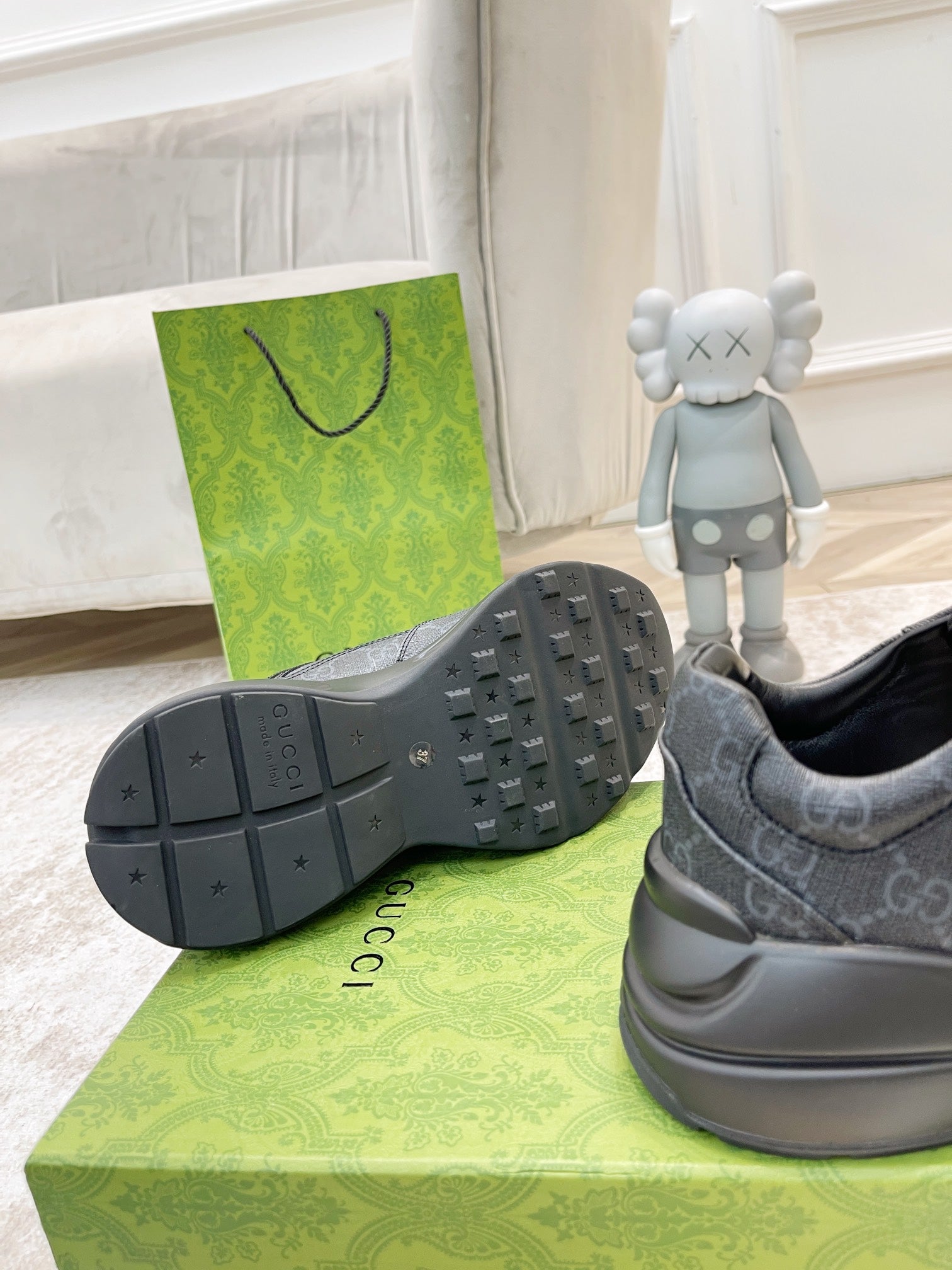 Gucci unisex sneaker outsole view in dark gray with tread pattern and side logo