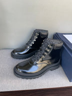Black lace-up ankle boots with metal rings and padded collar, on stand