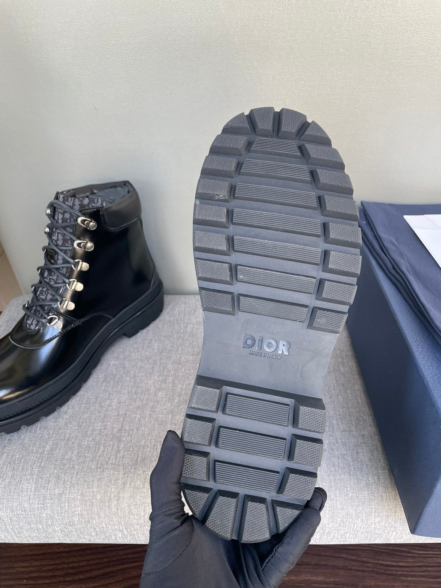 Outsole view of Dior black lace-up ankle boots with tread pattern
