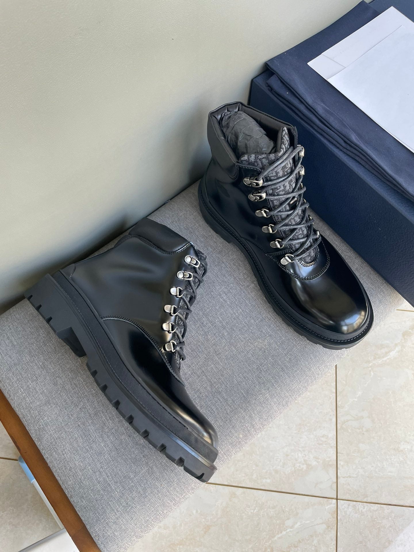 Dark lace-up ankle boots with metal eyelets and lug sole, pair on display