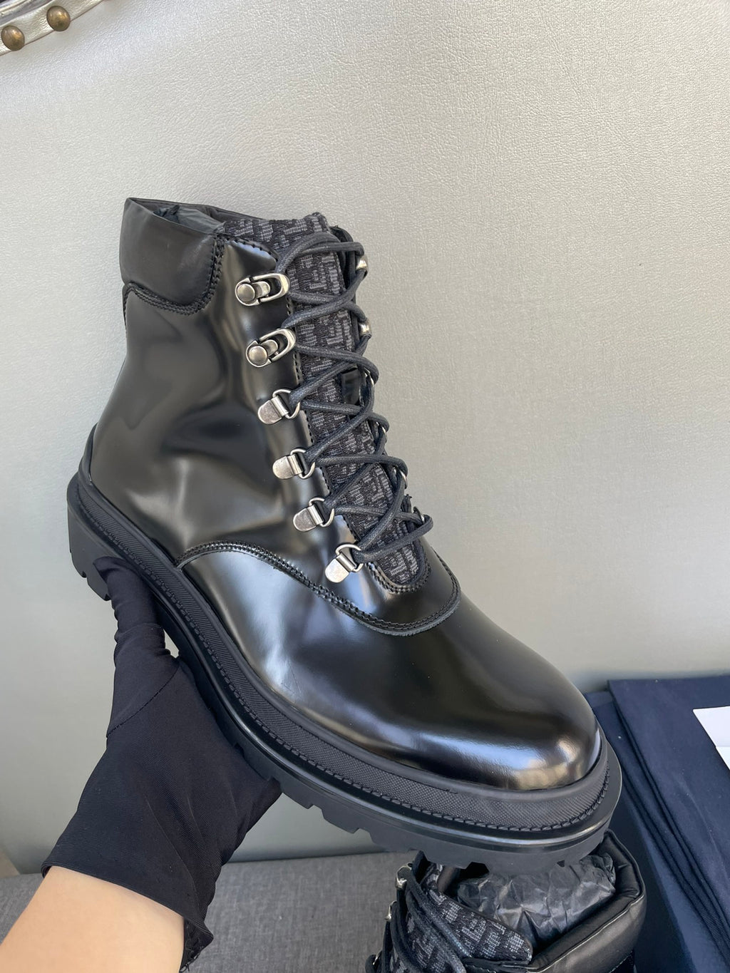 Black leather lace-up ankle boot with metal eyelets and stitched toe cap