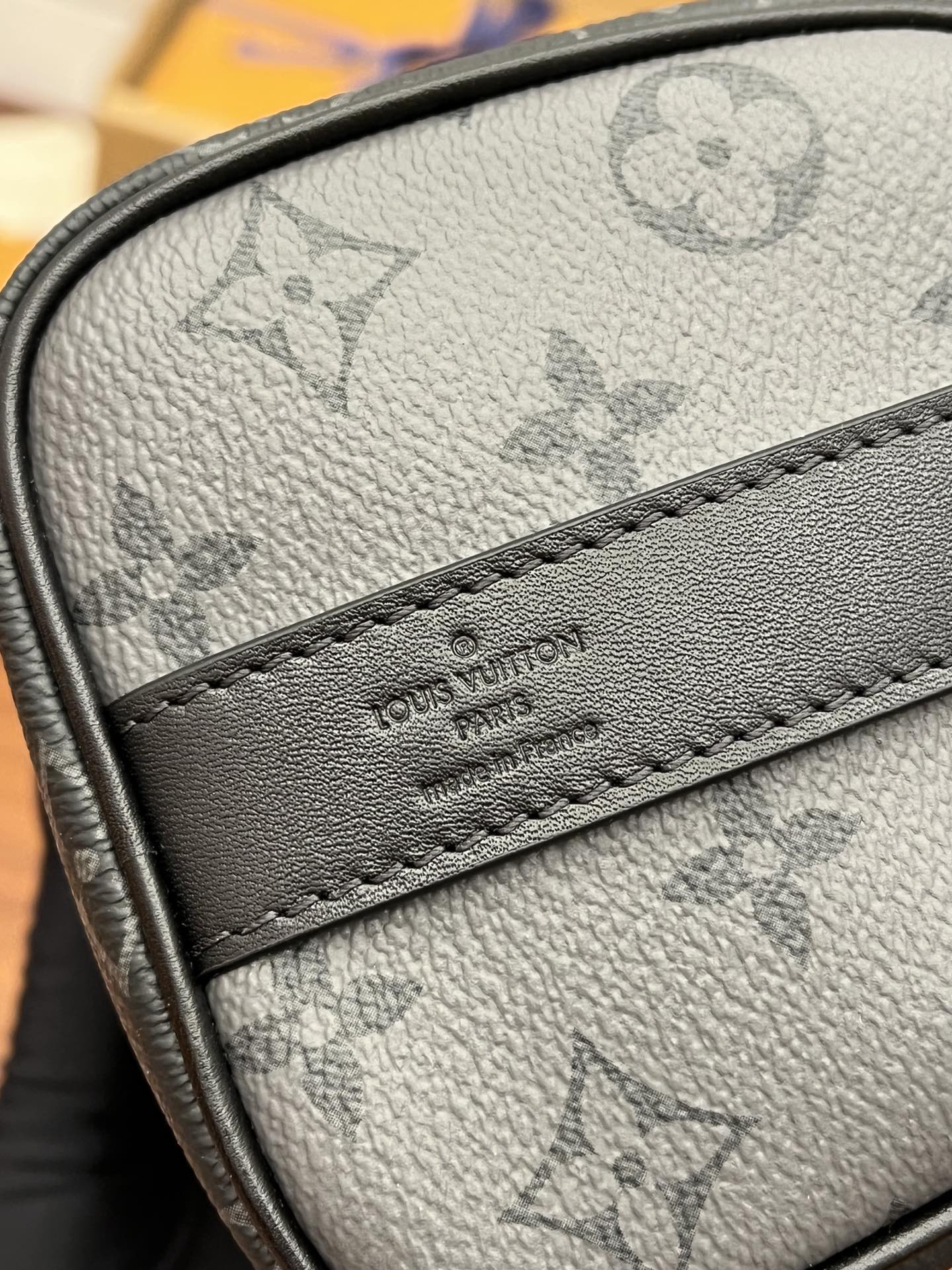 Men's Louis Vuitton monogram bag close-up of logo leather patch and stitching
