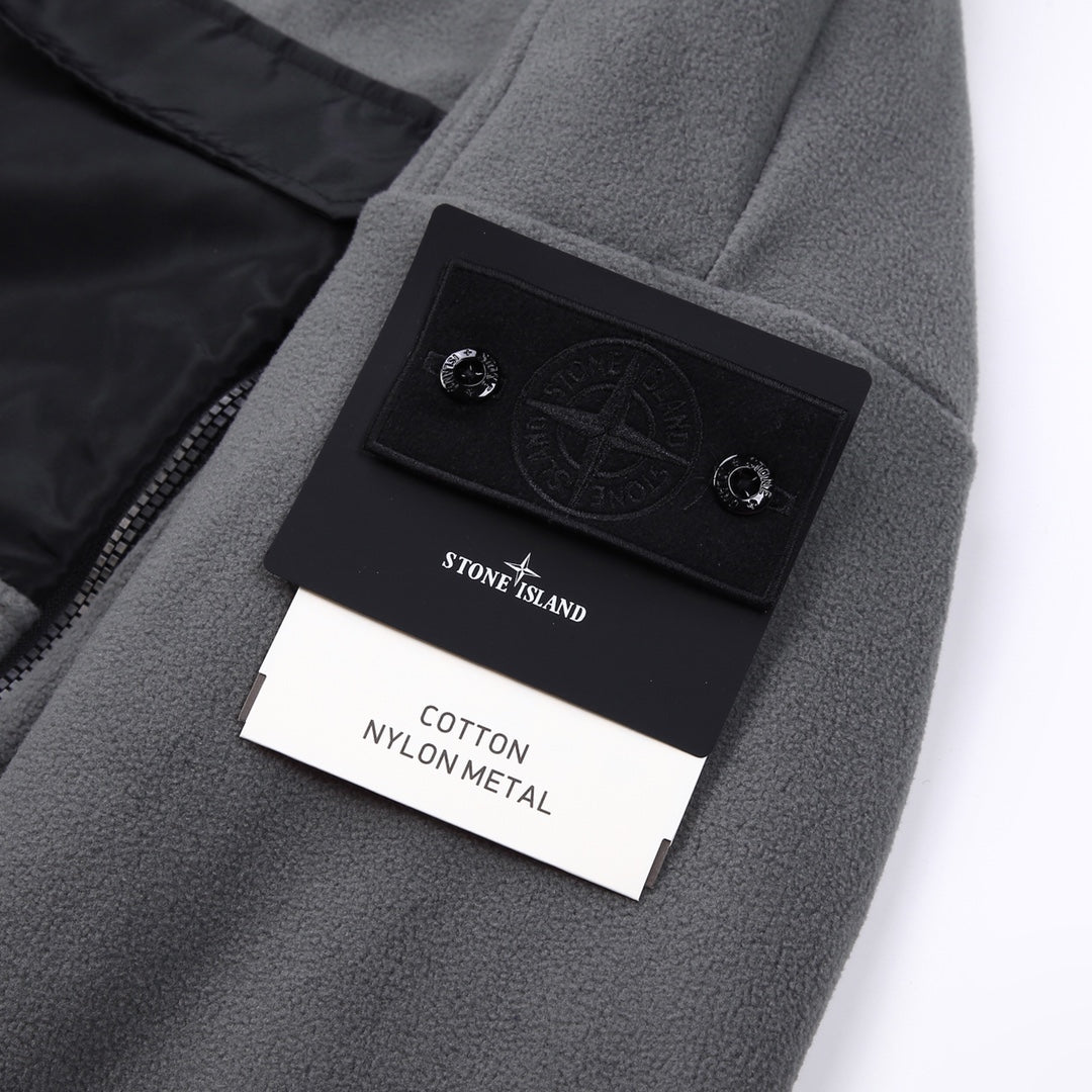 Stone Island jacket label area, gray fleece with black logo patch and tag