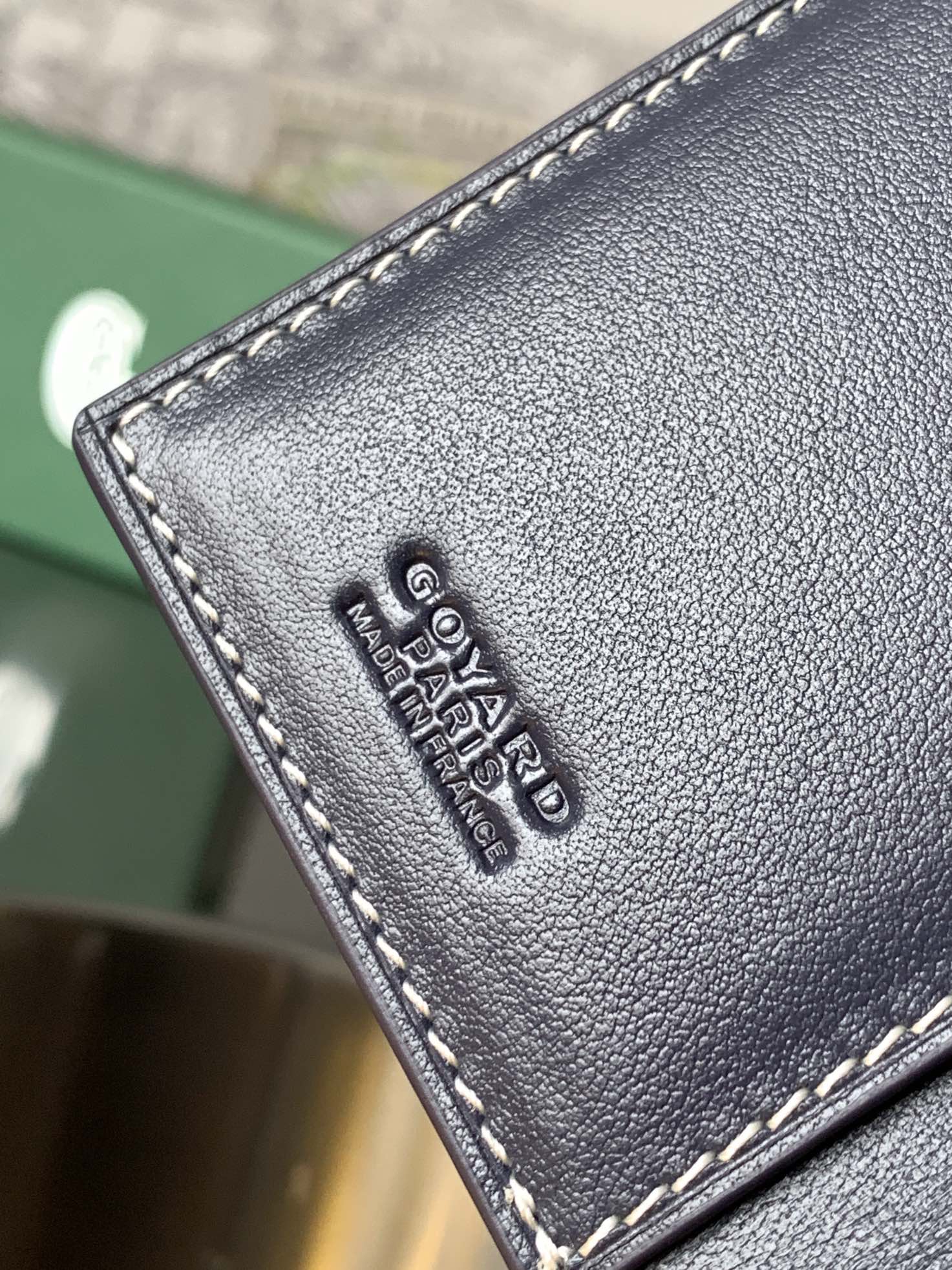 Small navy leather cardholder corner with embossed lettering and contrast stitching