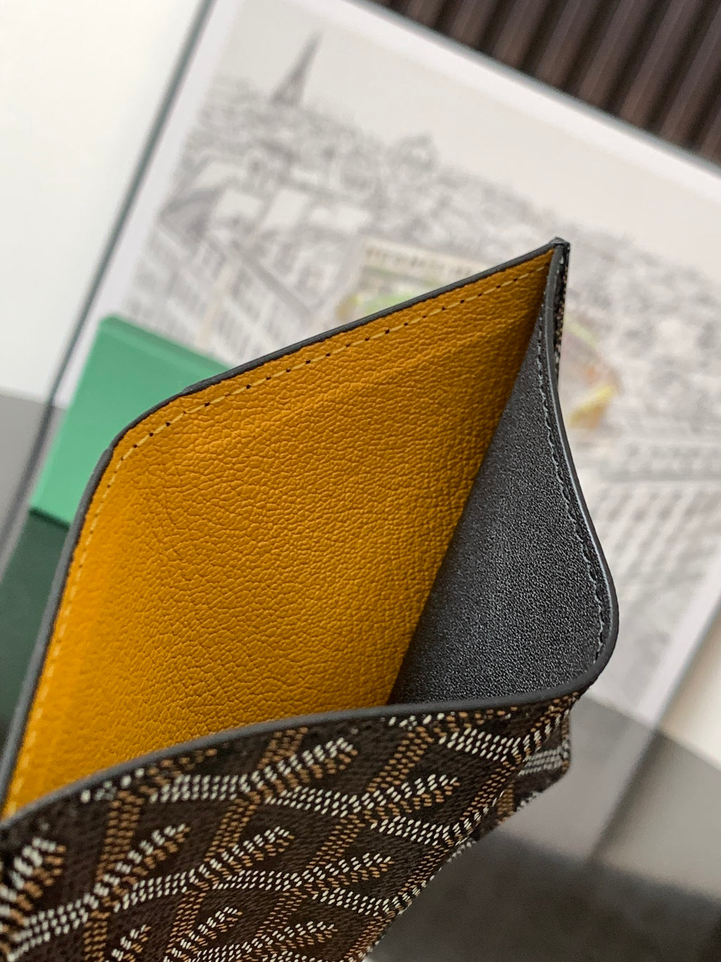 Goyard small bag corner close-up with mustard-yellow leather panel and black leather trim