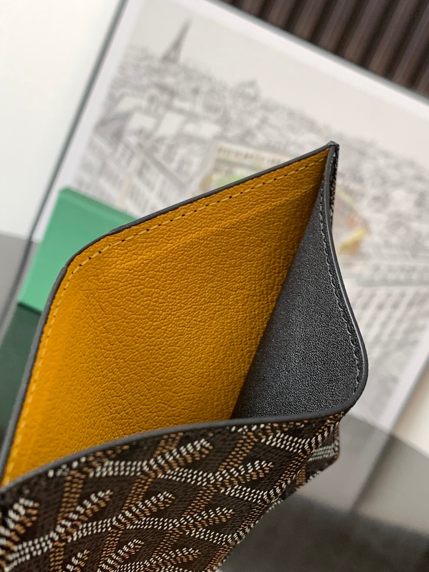 Goyard small bag corner close-up with mustard-yellow leather panel and black leather trim