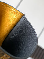 Black leather wallet with embossed lettering and pebbled texture, close-up
