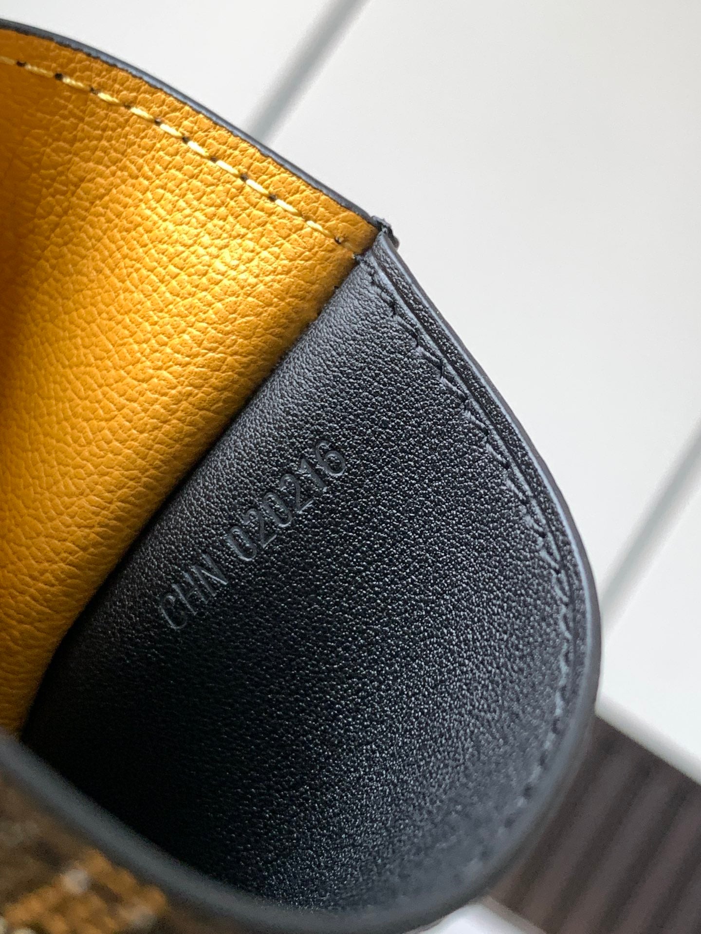 Black leather wallet with embossed lettering and pebbled texture, close-up