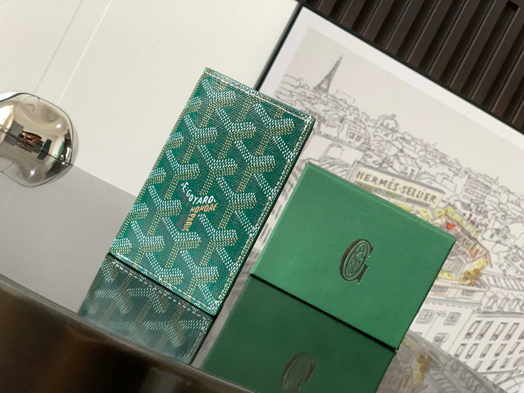 Green small bag with Goyard patterned exterior and flap closure, front view.