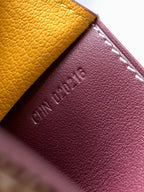 Maroon leather panel with embossed Goyard and white stitching