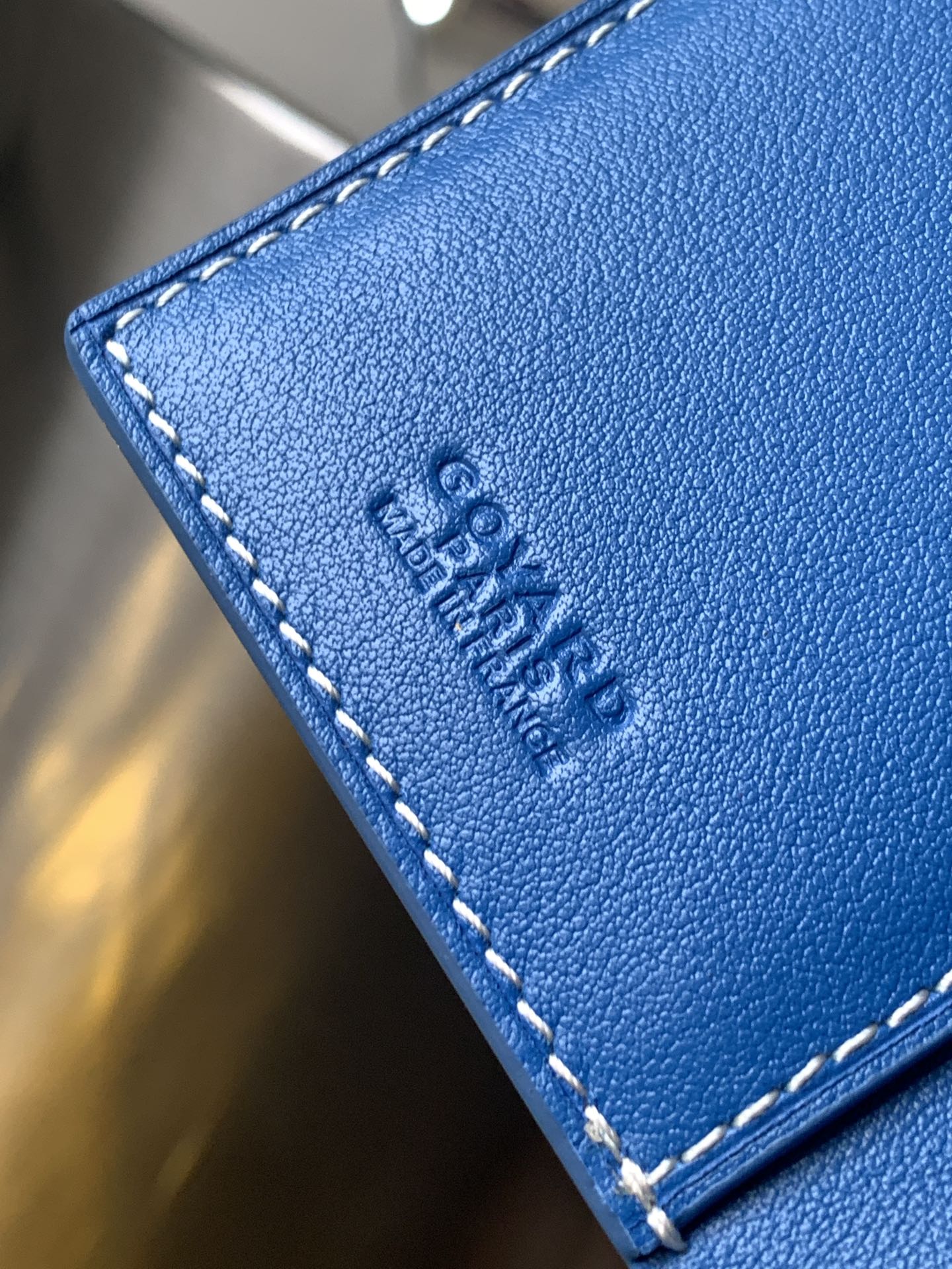 Goyard small bag corner in blue leather with visible stitching and embossed logo