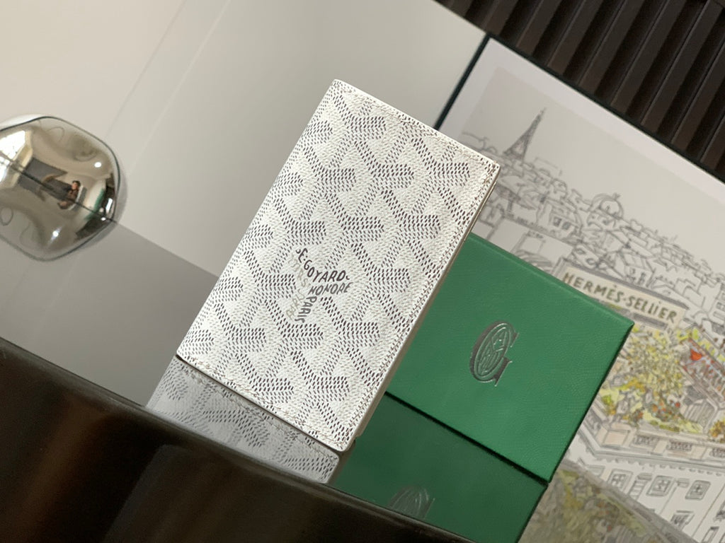Small bag with white patterned exterior and green front panel, stitched top edge